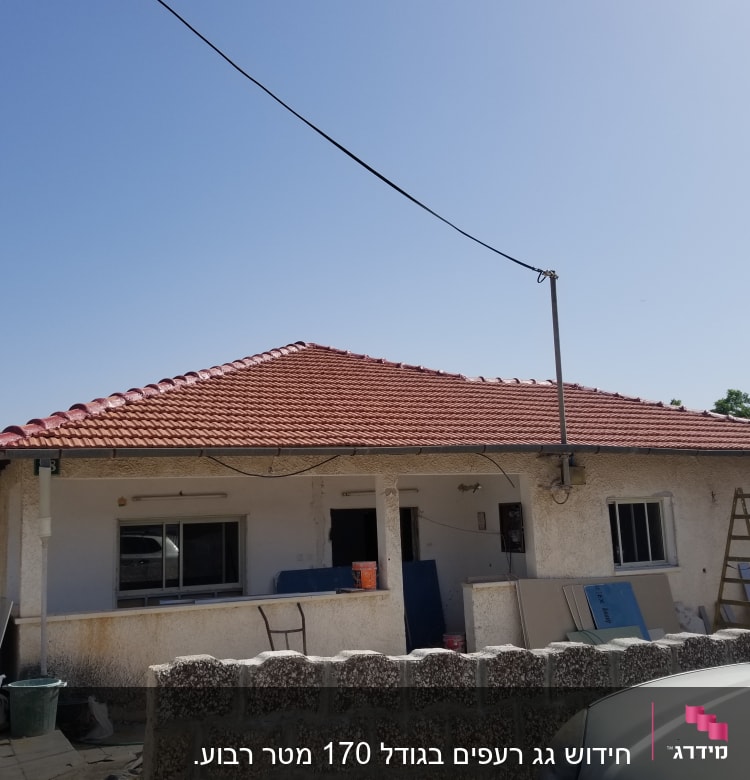 גג רעפים אדום עם אנטנה על גג בית